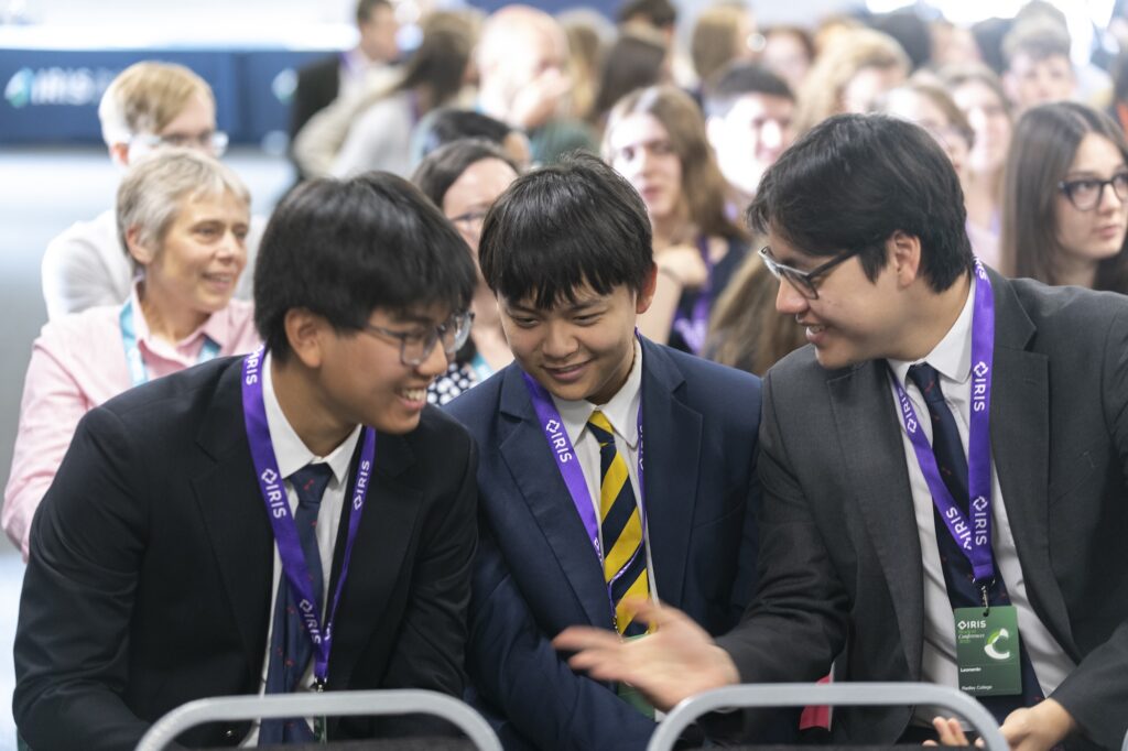 Students talking to each other in crowd at IRIS student conferences
